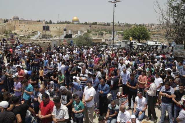 الفلسطينيون يصلون أمام بوابات المسجد الاقصي اليوم قبل اندلاع المواجهات